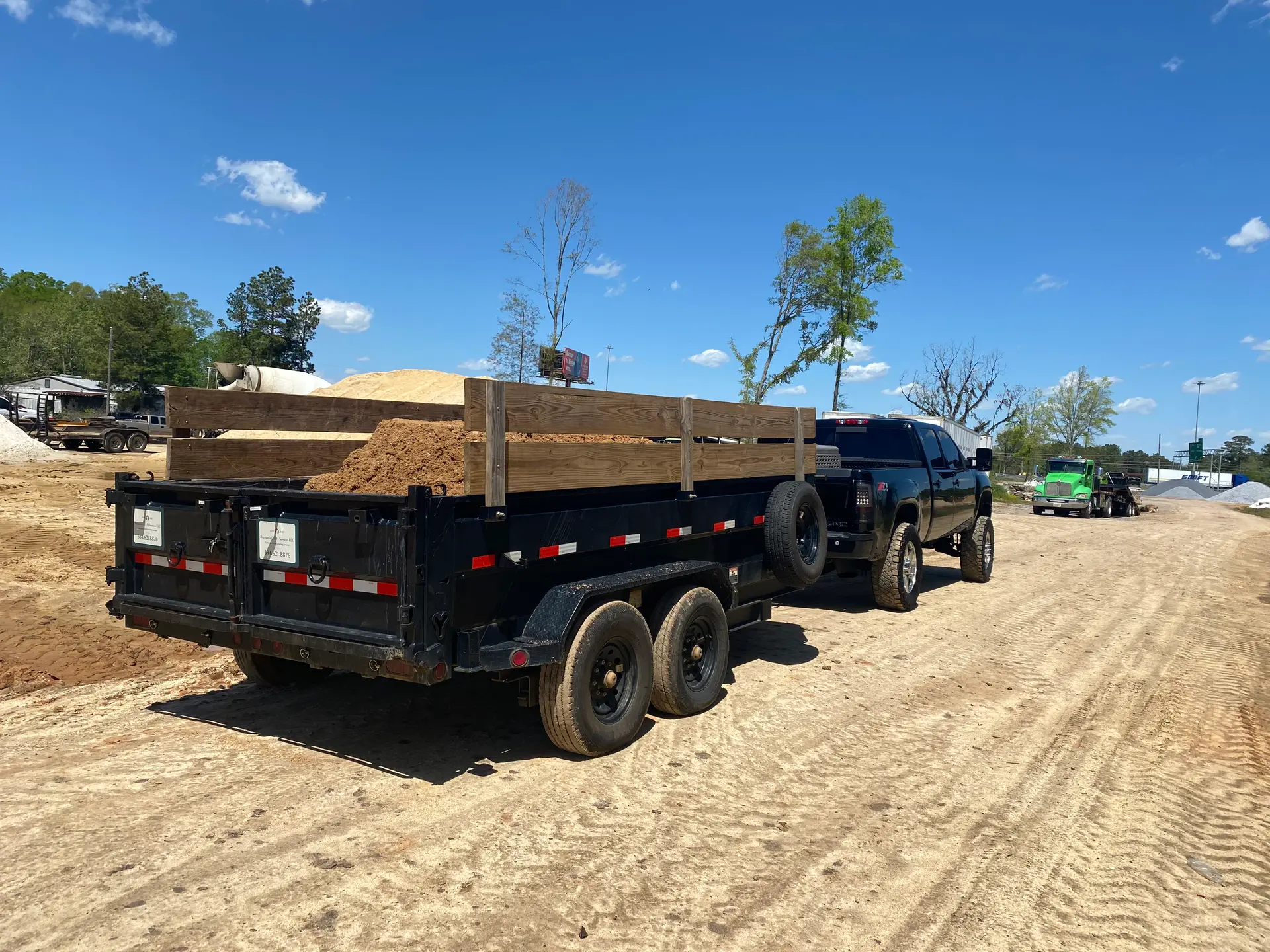 Melanin Site Solutions truck and loaded dump trailer on a Montgomery job site