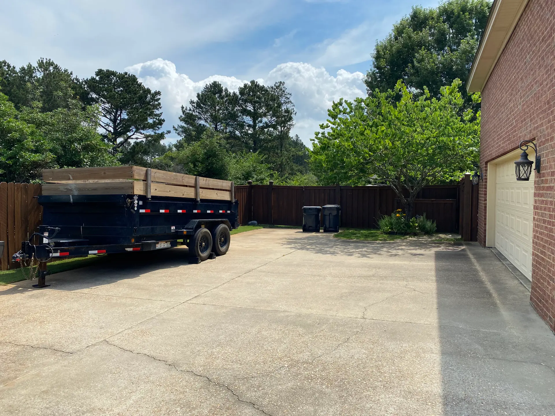 Roll-off style dump trailer delivered to a residential driveway in the River Region
