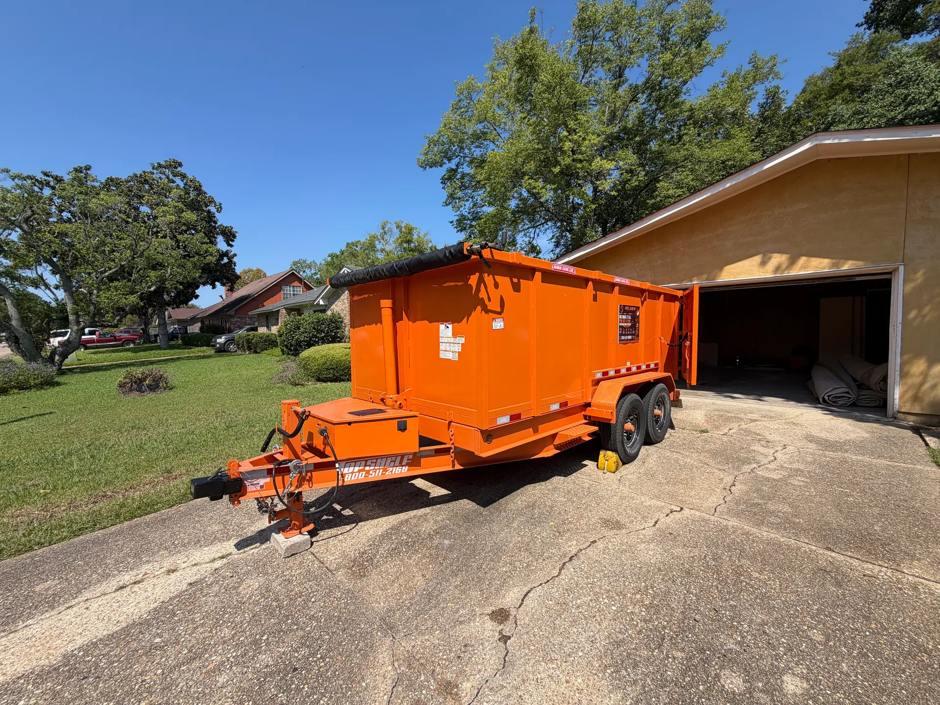 Orange SiteTub 15-yard Tub parked in a Montgomery driveway beside an open garage